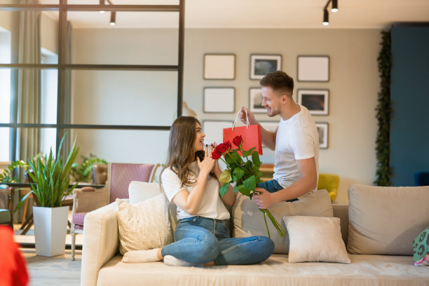 一名年轻人在圣瓦伦丁节这天用鲜花和礼物给他心爱的妻子一个惊喜图片下载