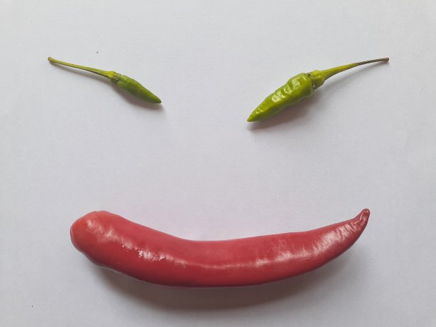 红辣椒和绿辣椒形成脸。俯视图近距离细节图片下载