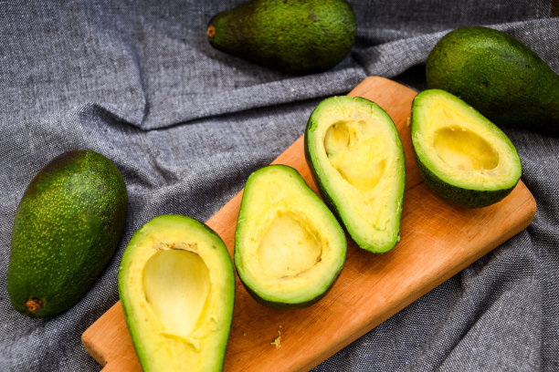 新鲜牛油果切成两半，成熟的牛油果和带骨的牛油果。图片下载