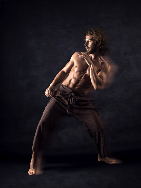 赤膊男子在黑色背景下锻炼图片下载