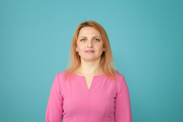 一个35岁的金发女人在蓝色背景上的工作室肖像图片下载