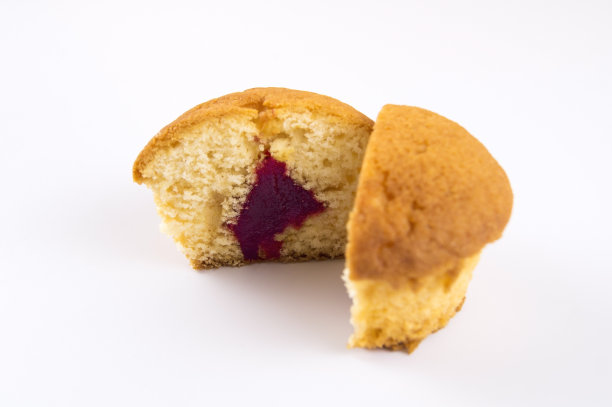 在浅色的背景下涂上红果酱的两半派图片下载