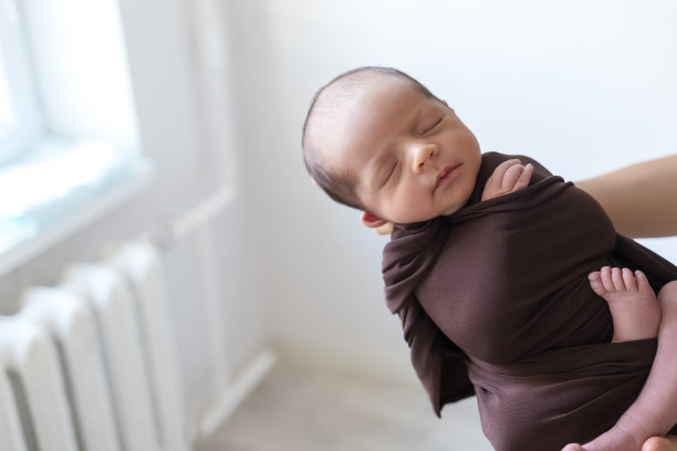 刚出生的小男孩在他妈妈的手里。新生儿摄影。图片下载