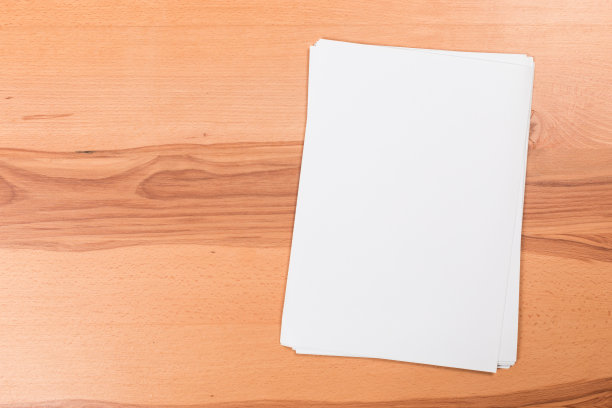 俯视图的现代办公桌办公场所与a4纸。品牌空白模板。照片空白表格。为作品集设计模拟。图片下载