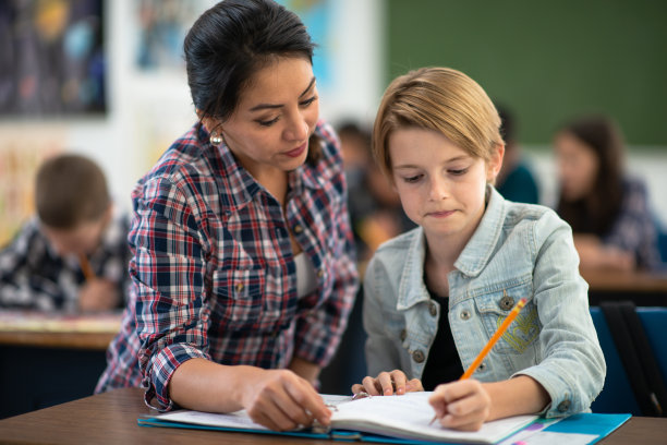 西班牙女教师帮助小学生储存照片图片下载