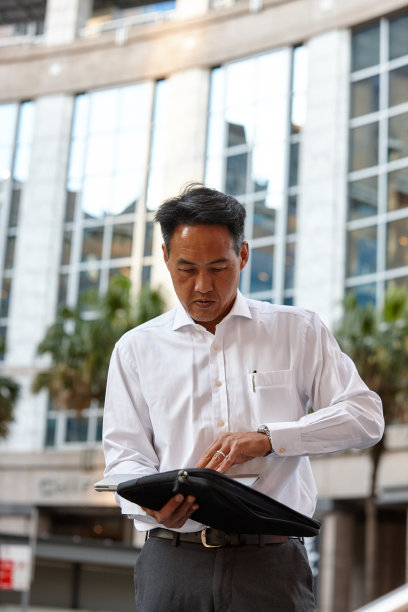 澳大利亚商人站在城市里用笔记本电脑工作图片下载