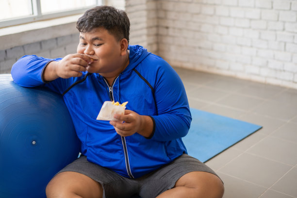 胖子吃薯条很开心。运动前图片下载