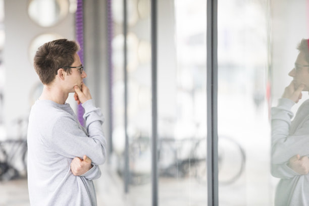 肖像年轻的成年人在城市街道上橱窗购物-库存照片图片下载