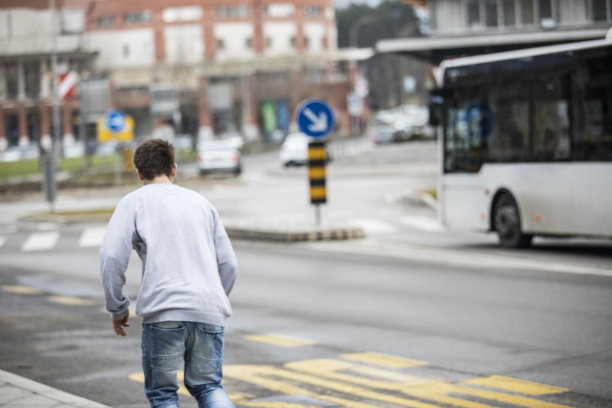 年轻人试图赶上一辆公共汽车在城市街道-库存照片图片下载