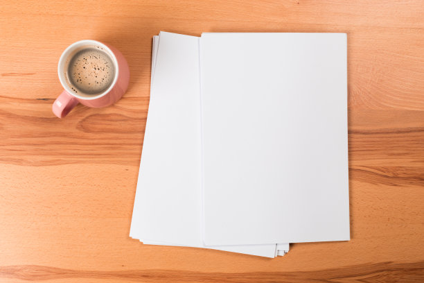 俯视图的现代办公桌办公场所与a4纸。品牌空白模板。照片空白表格。为作品集设计模拟。图片下载