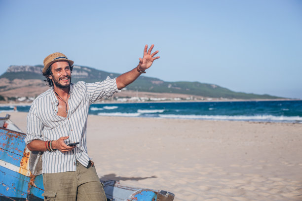 戴着帽子挥手的帅气男人图片下载