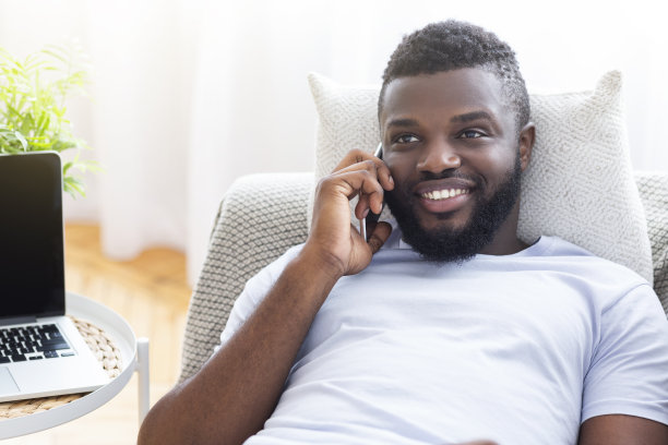 微笑的非裔美国人在家里打电话图片下载