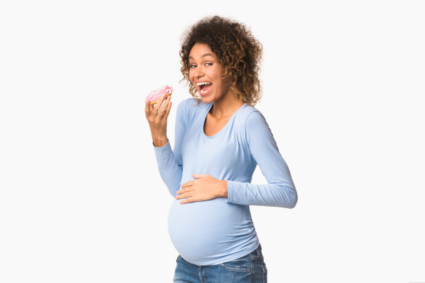 饥饿的孕妇吃着甜甜圈，白色背景图片下载