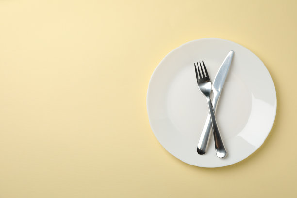盘与叉和刀米色背景，俯视图图片下载