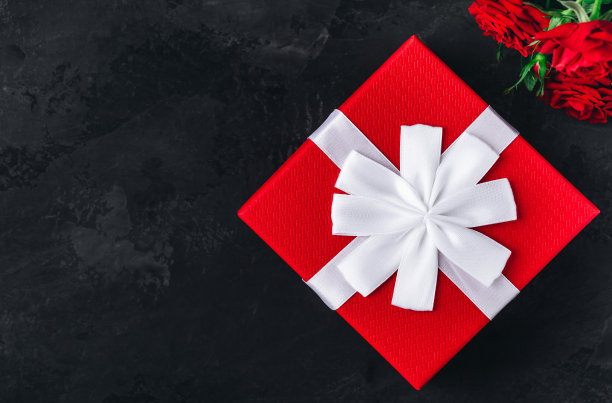 情人节背景卡。红色礼盒和红色玫瑰在黑暗的石头背景图片下载