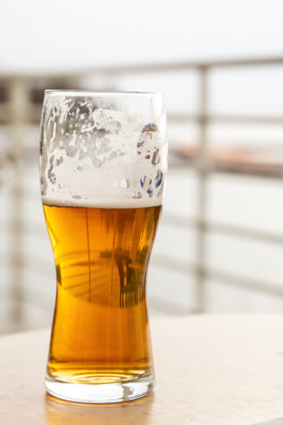 一杯冰凉的啤酒垂直照片上模糊的背景夏日咖啡馆图片下载