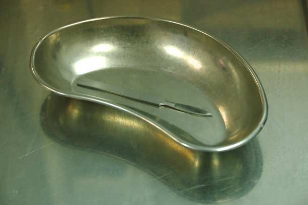 在医务室的金属桌子上放置金属托盘、手术刀和医用手套图片下载