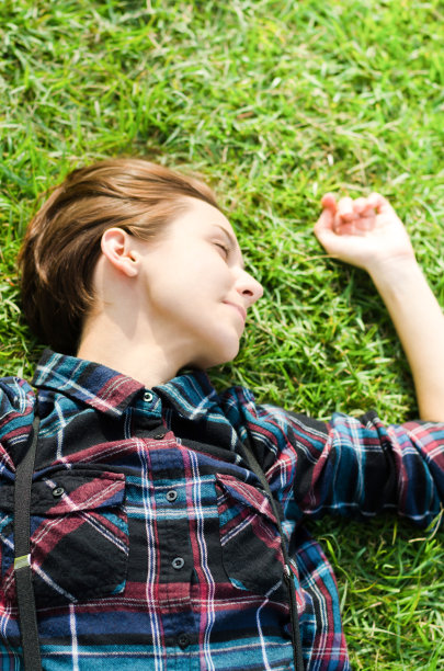 年轻女子躺在草地上图片下载
