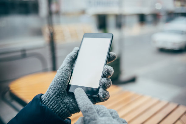 女人的手戴着手套在用手机图片下载