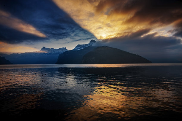 在卢塞恩湖日落时，天空和云彩中戏剧性的倒影素材图片
