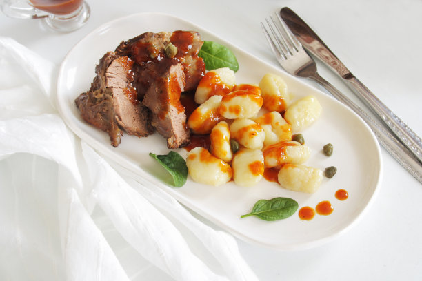 烤鹿肉和汤团放在白色盘子里图片下载