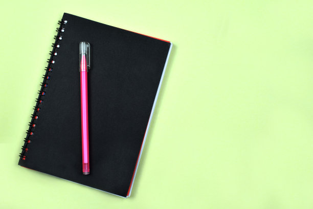 一只粉红色的钢笔在日记本上面，准备写图片下载