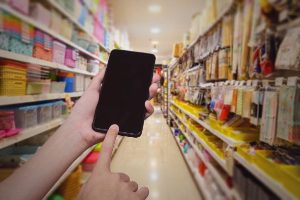 手持智能手机在超市购物或付款。技术的概念。图片下载