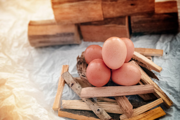 一组鸡蛋放在木棒上，模糊的灯光背景图片下载