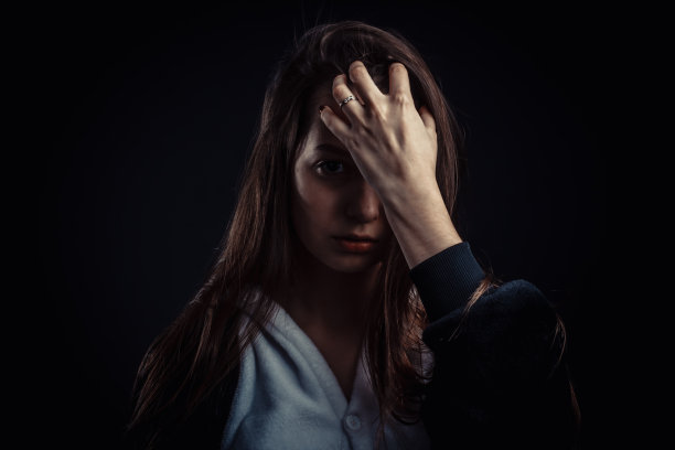 画室里一个深色头发的女孩的肖像，背景是纯黑色，穿着黑白睡衣，戴着兜帽图片下载