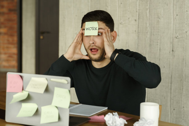 坐在办公室笔记本电脑前到处贴便利贴的人图片下载