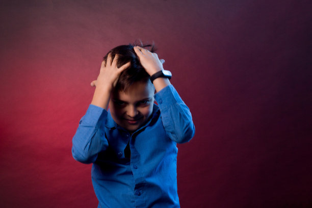 那男孩穿着一件蓝色衬衫，背景是紫色和栗色。图片下载