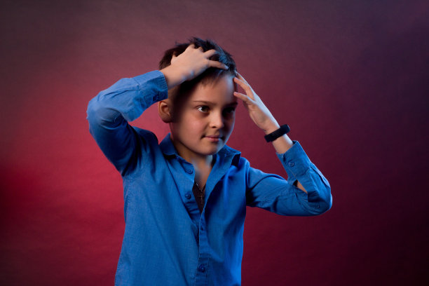 那男孩穿着一件蓝色衬衫，背景是紫色和栗色。图片下载