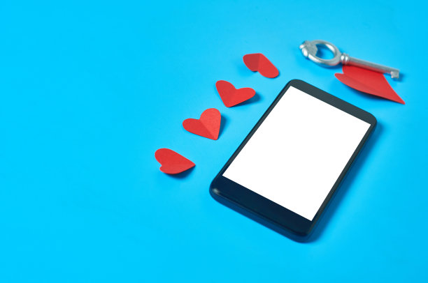 黑色智能手机与孤立的白色屏幕文本，图片，照片和其他图形附近的纸心和古董钥匙在蓝色的桌子。秘密或禁忌的爱的概念。空间的文本图片下载