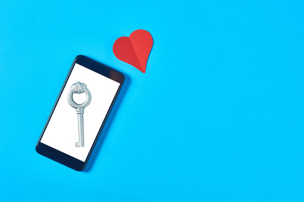 黑色智能手机与孤立的白色屏幕的文字，图片，照片和其他图形与复古的关键纸心在蓝色的桌子。秘密或禁忌的爱的概念。前视图。空间的文本图片下载