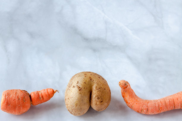 时髦有趣丑陋的有机家庭种植蔬菜土豆和两根胡萝卜在灰蓝色大理石背景与复制空间图片下载