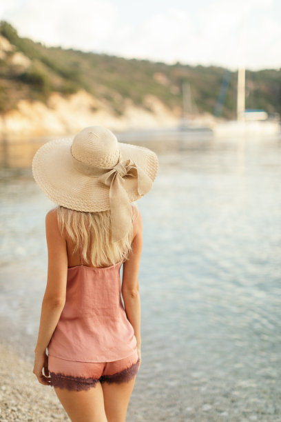 海滩上戴着帽子的漂亮女人图片下载