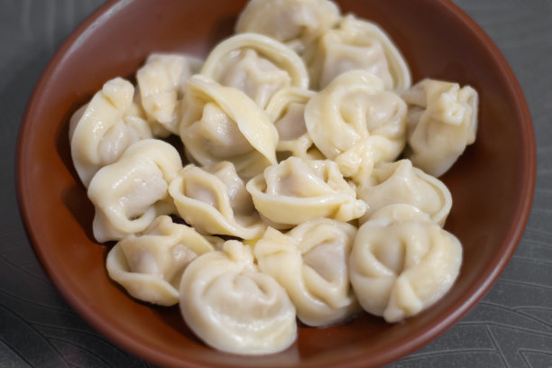 俄罗斯水饺放在棕色的盘子里放在桌子上图片下载