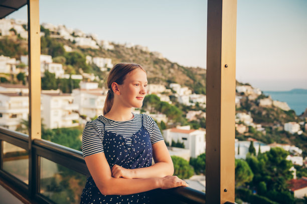 年轻的女孩在阳台上欣赏美丽的风景，暑假在海边，家人带着孩子旅行图片下载