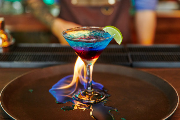 鸡尾酒与石灰燃烧火在玻璃高脚杯，酒精图片下载