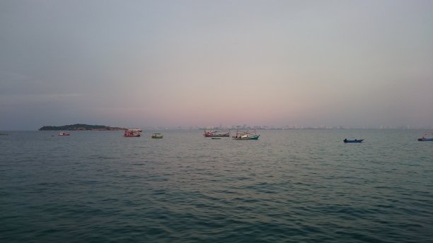 海与一些渔民的拉恩岛，城市景观芭堤雅在地平线上图片下载