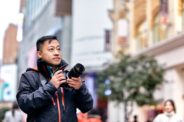 用数码相机在城市中拍摄的男性旅行者图片下载