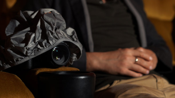 一个男人一边看电影，一边偷偷地拍电影。图片下载