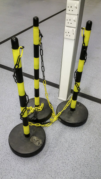 仓库地板上有三根黄色和黑色的安全链护栏图片下载