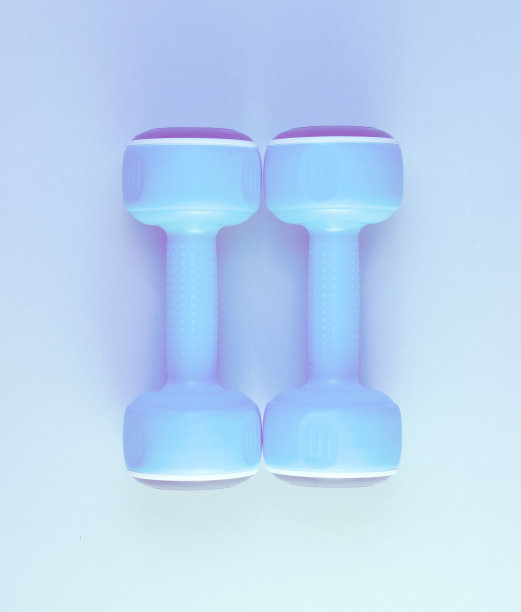 极简主义运动的概念。两个蓝色塑料哑铃，蓝色全息光。俯视图图片下载