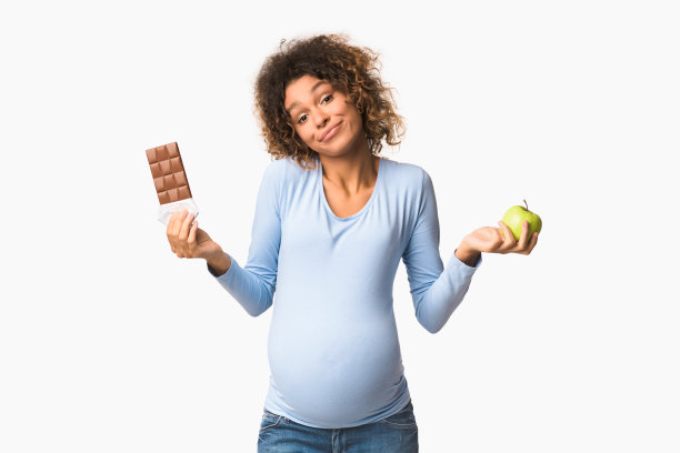 困惑的非洲裔怀孕女孩拿着苹果和巧克力图片下载