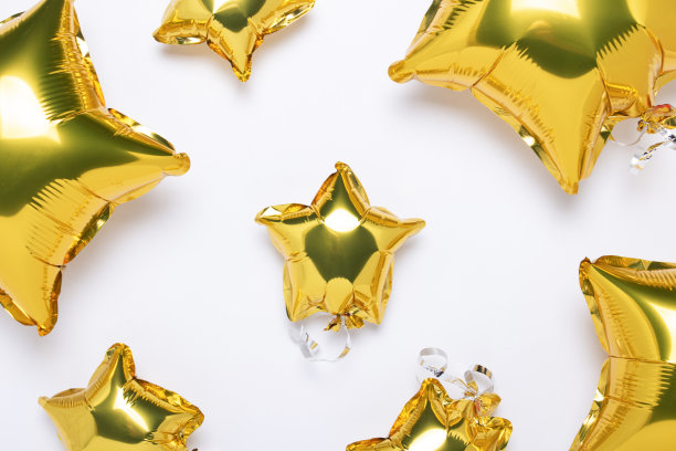 空中金色的气球，星星形状和糖果在白色的背景。假日，派对，照片区，装饰的概念。横幅平躺，俯视图图片下载