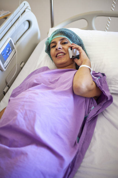 孕妇在医院里用手机打电话准备分娩图片下载