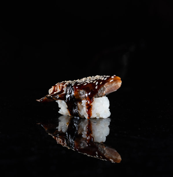 日本寿司孤立在黑色背景。镜子表面的反射。关闭了。工作室的照片。图片下载