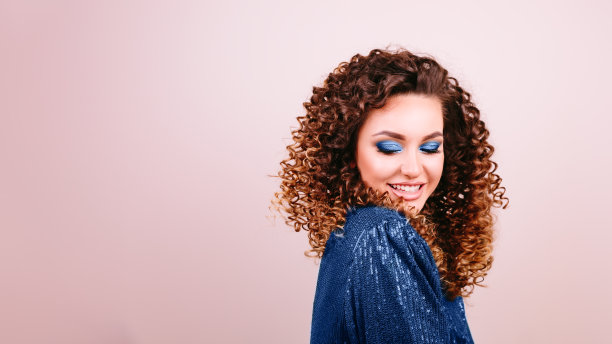 性感时尚的女人微笑着亮蓝色的裙子和高跟鞋，漂亮的黑发。工作室的照片。方的概念。经典的2020年蓝色。图片下载