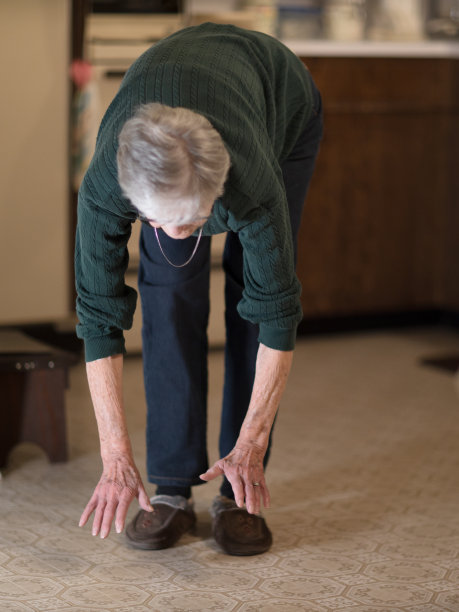 妇女弯腰触摸地板图片下载